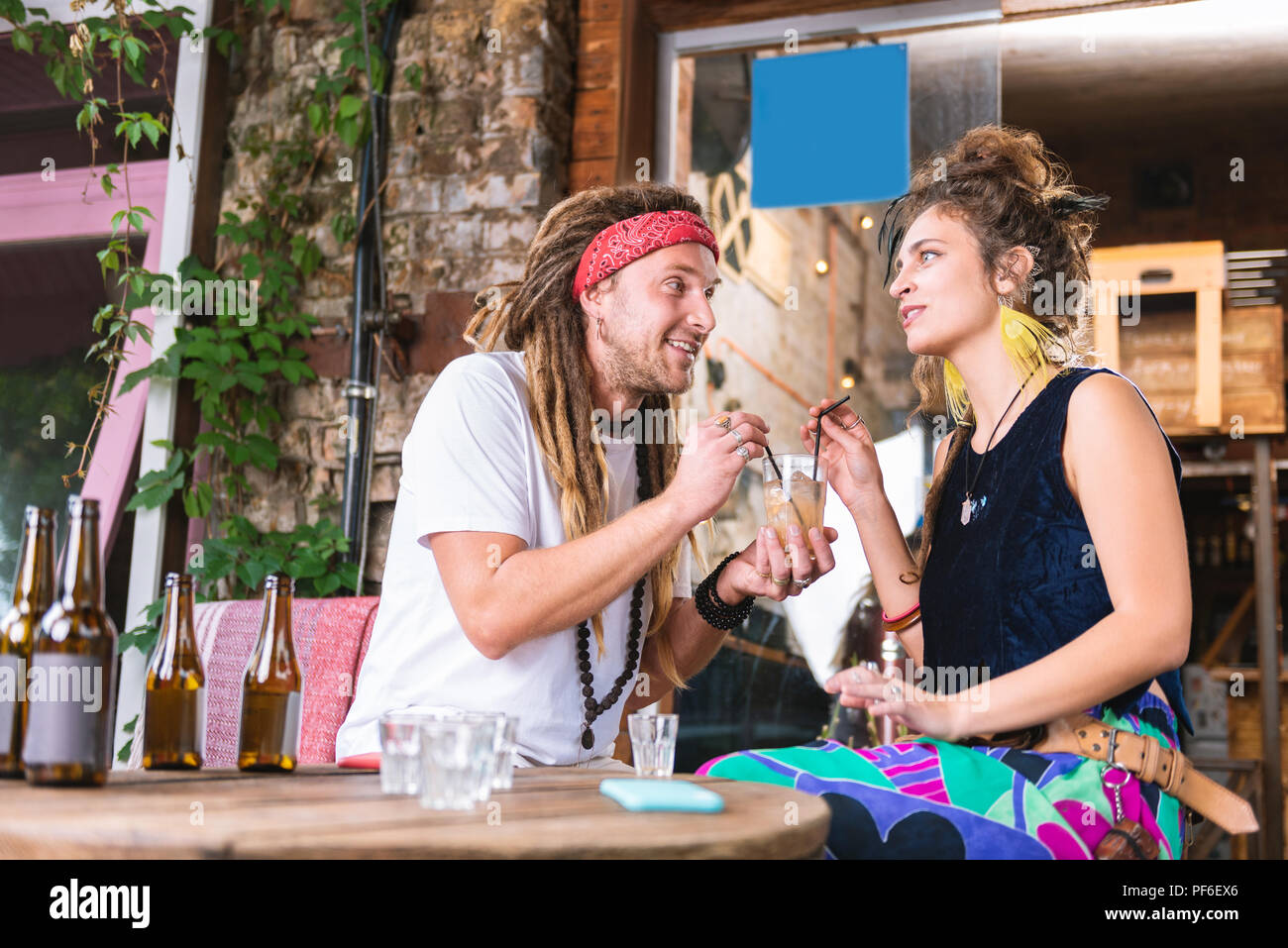 Paar Hippies am Tisch trinken Alkohol Getränke sitzen Stockfoto