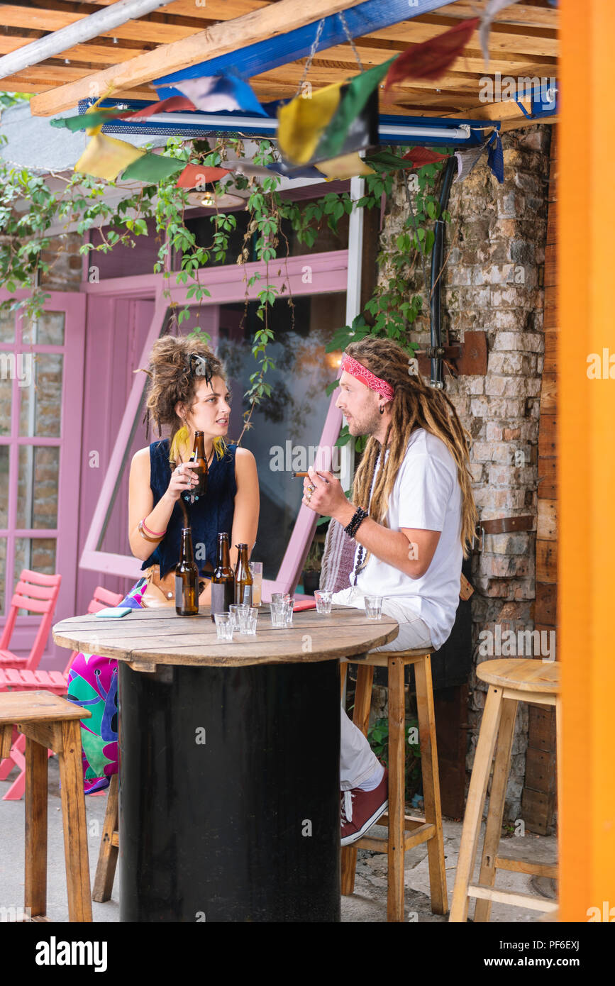Paar hippies Trinken und Rauchen auf der Sommerterrasse sitzen Stockfoto