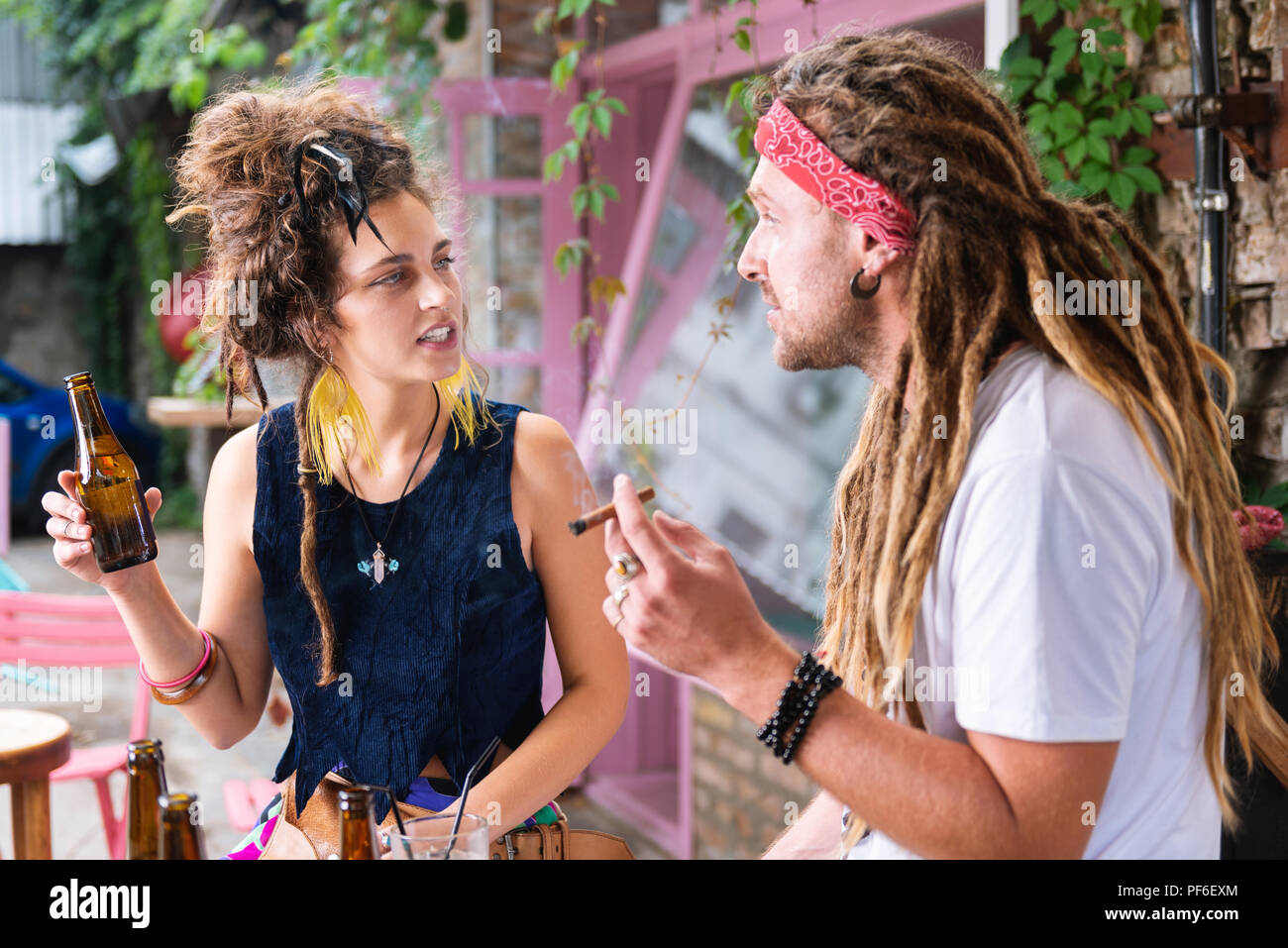 Stilvolle hippie Mann rauchen Zigarre sitzen mit Freundin Stockfoto