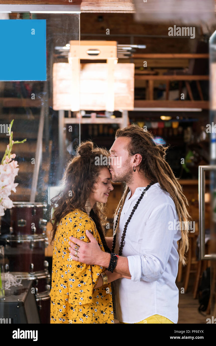 Hippie Mann mit langen Haaren küssen sein strahlendes Freundin Stockfoto