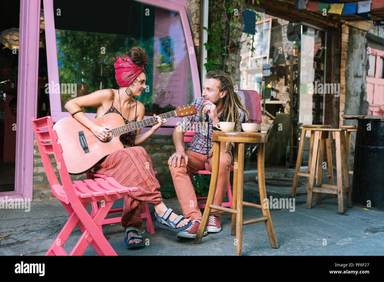 Hippie Mann hören auf seine Freundin Musik wiedergeben Stockfoto