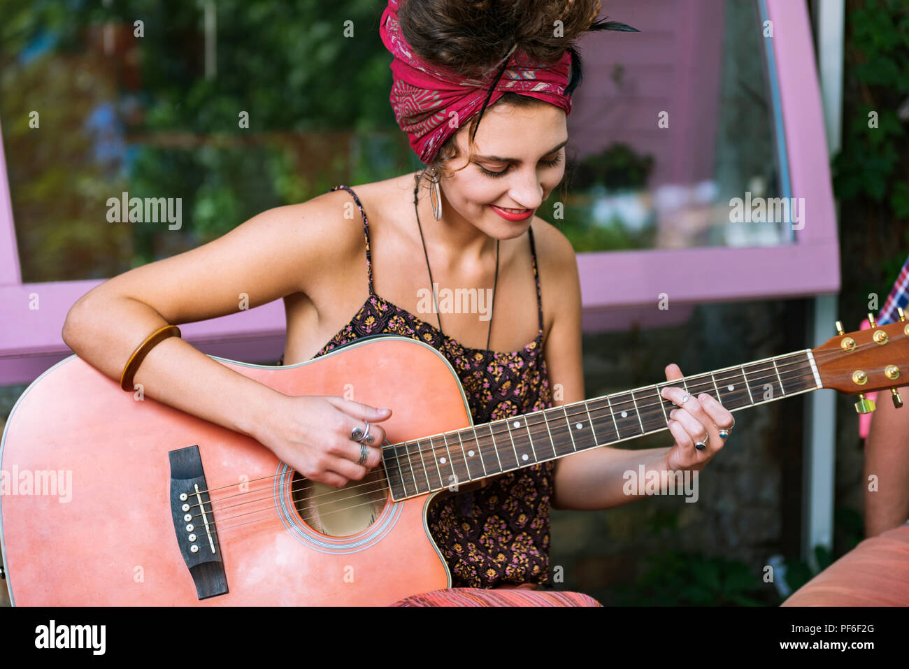 Schöne weibliche Musiker spielen auf der Gitarre im Cafe sitzen Stockfoto