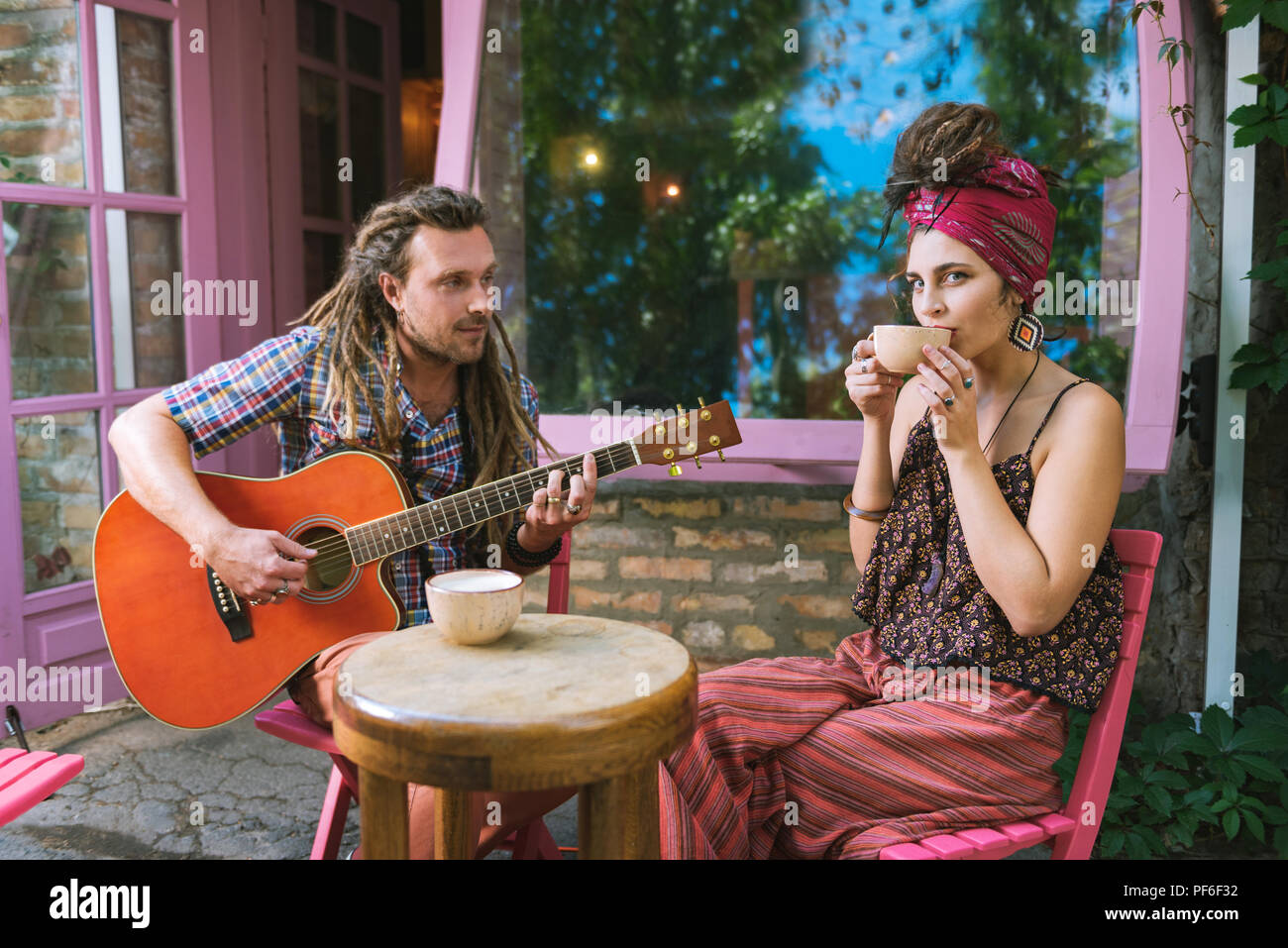 Stilvolle hippie Frau im Cafe sitzt mit ihrem Freund Stockfoto