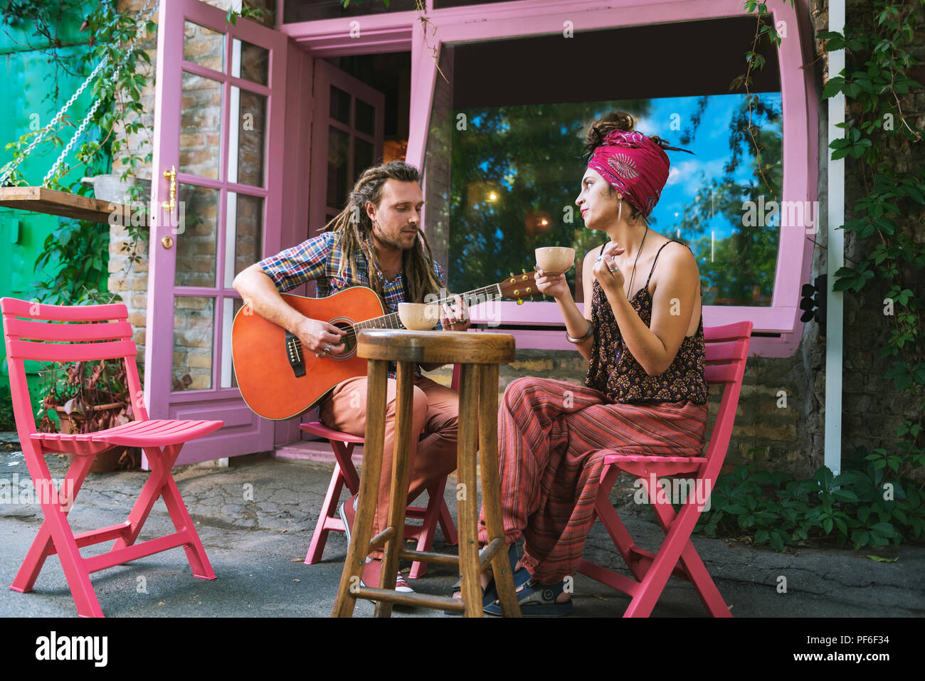 Paar kreative Musiker Tee trinken und Gitarre spielen Stockfoto