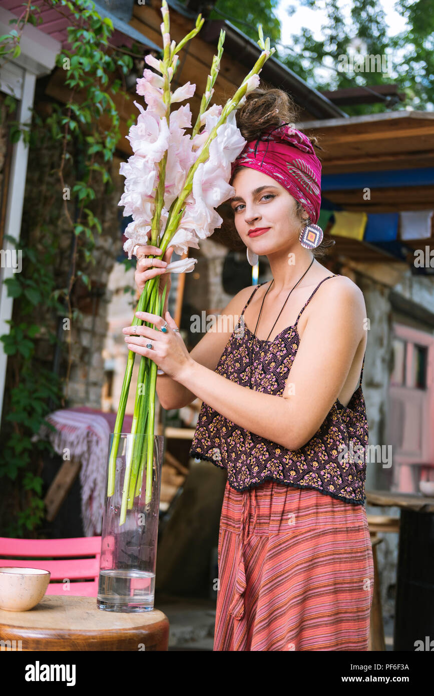 Eigentümer der Hippie Cafe, weiße Blumen in Vase Stockfoto