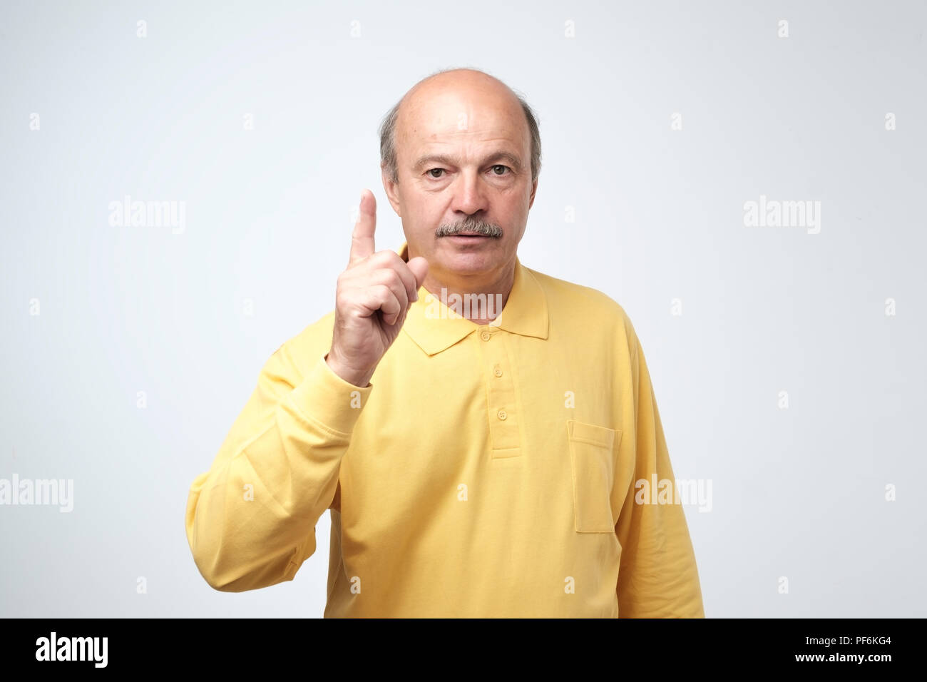 Sie sind nicht laut, es zu tun. Strenge schöne Reife glatzköpfige Mann verbietet etwas zu wählen, nach oben gerichtet sein. Stockfoto