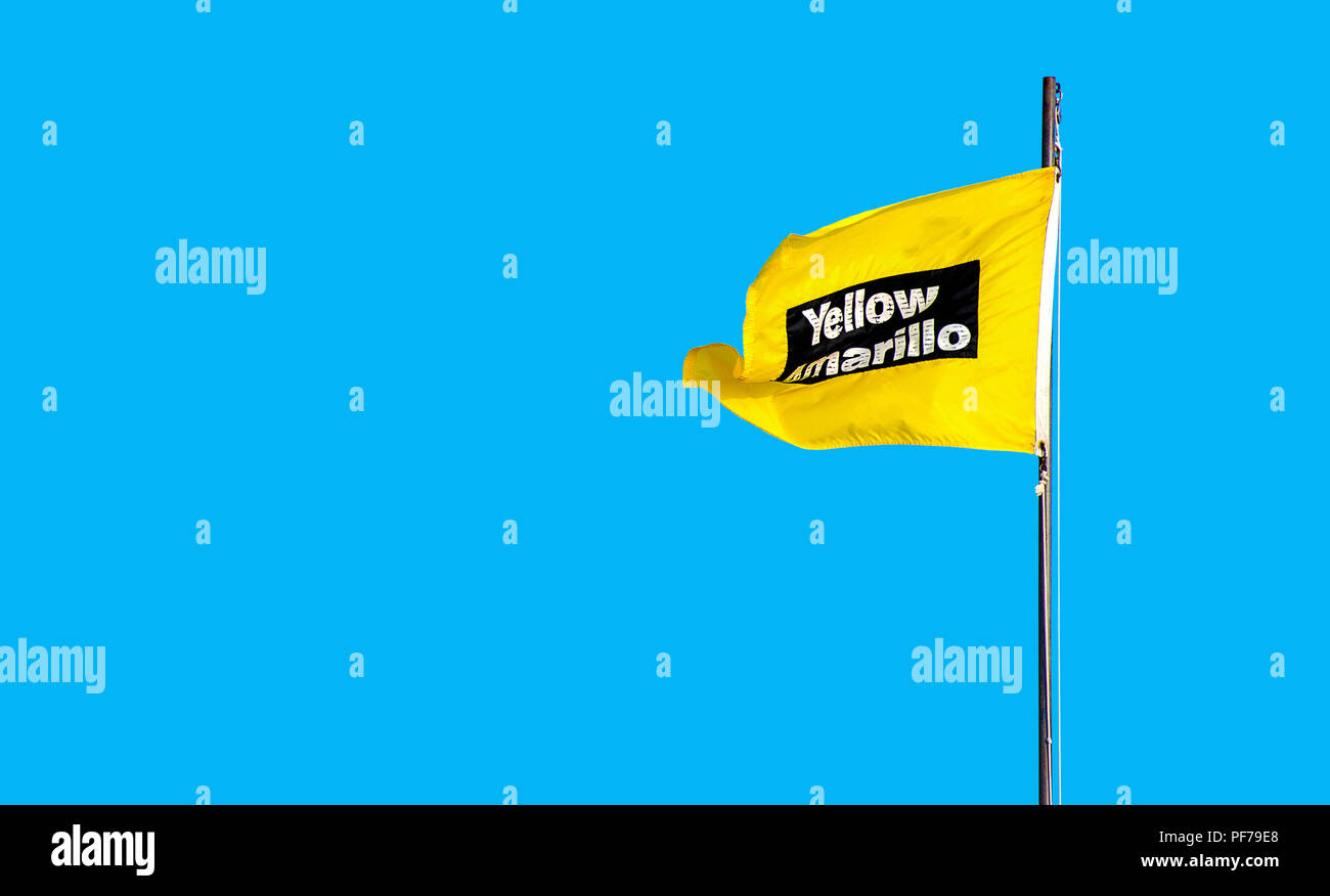 Gelbe Achtung-beach Flag auf hellen blauen Sommerhimmel Hintergrund mit Englisch und Spanisch Übersetzung Stockfoto