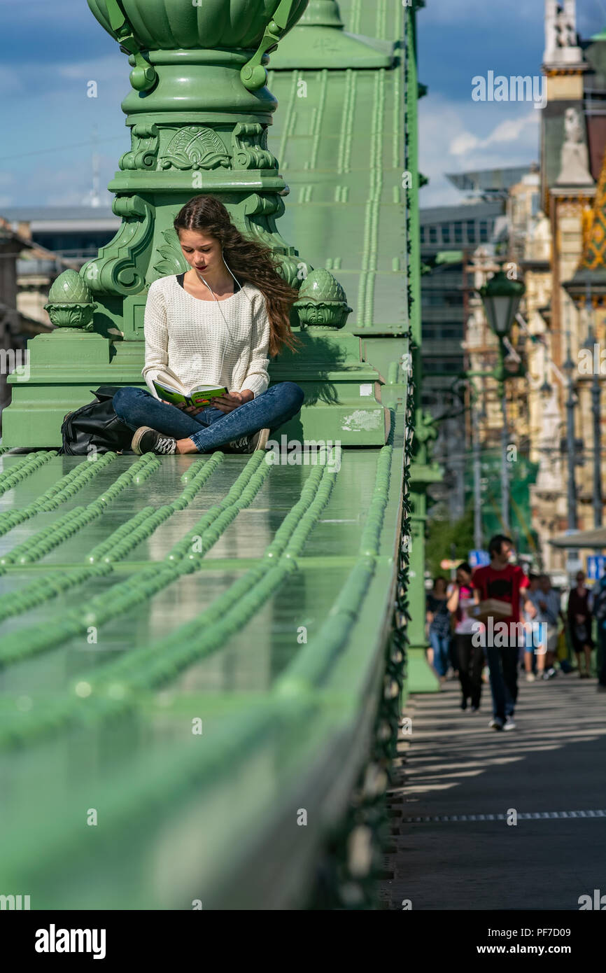 Lesen student Mädchen an der berühmten Budapester Freiheitsbrücke, wie Freiheit, oder sogar Grüne Brücke bekannt Stockfoto