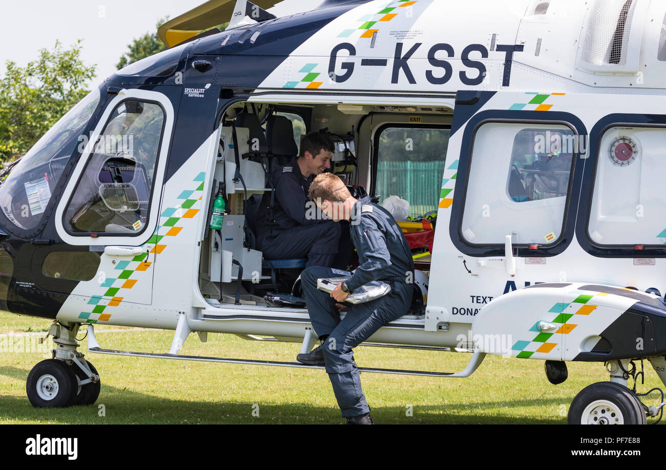 Surrey and Sussex Air Ambulance Helicopter (G-KSST) auf dem Boden mit dem Personal unterhalten, in West Sussex, England, UK. Flugzeug AgustaWestland AW169. Stockfoto
