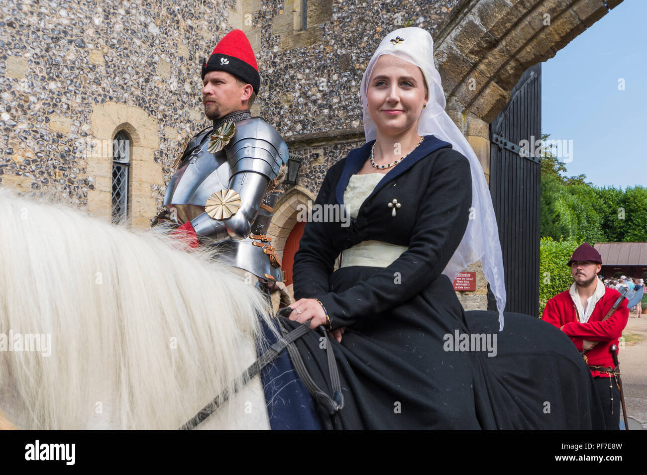 Leute auf dem Rücken der Pferde bei einem schwertkampf Ereignis in traditionelle mittelalterliche Kleidung in Arundel, West Sussex, England, UK gekleidet. Mittelalter Kostüme. Stockfoto