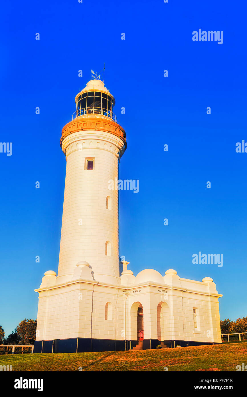Weißer Stein Norah Head Lighthouse im warmen Morgenlicht gegen strahlend blauen Himmel auf Australian Pacific Coast Park der Nationalpark. Stockfoto