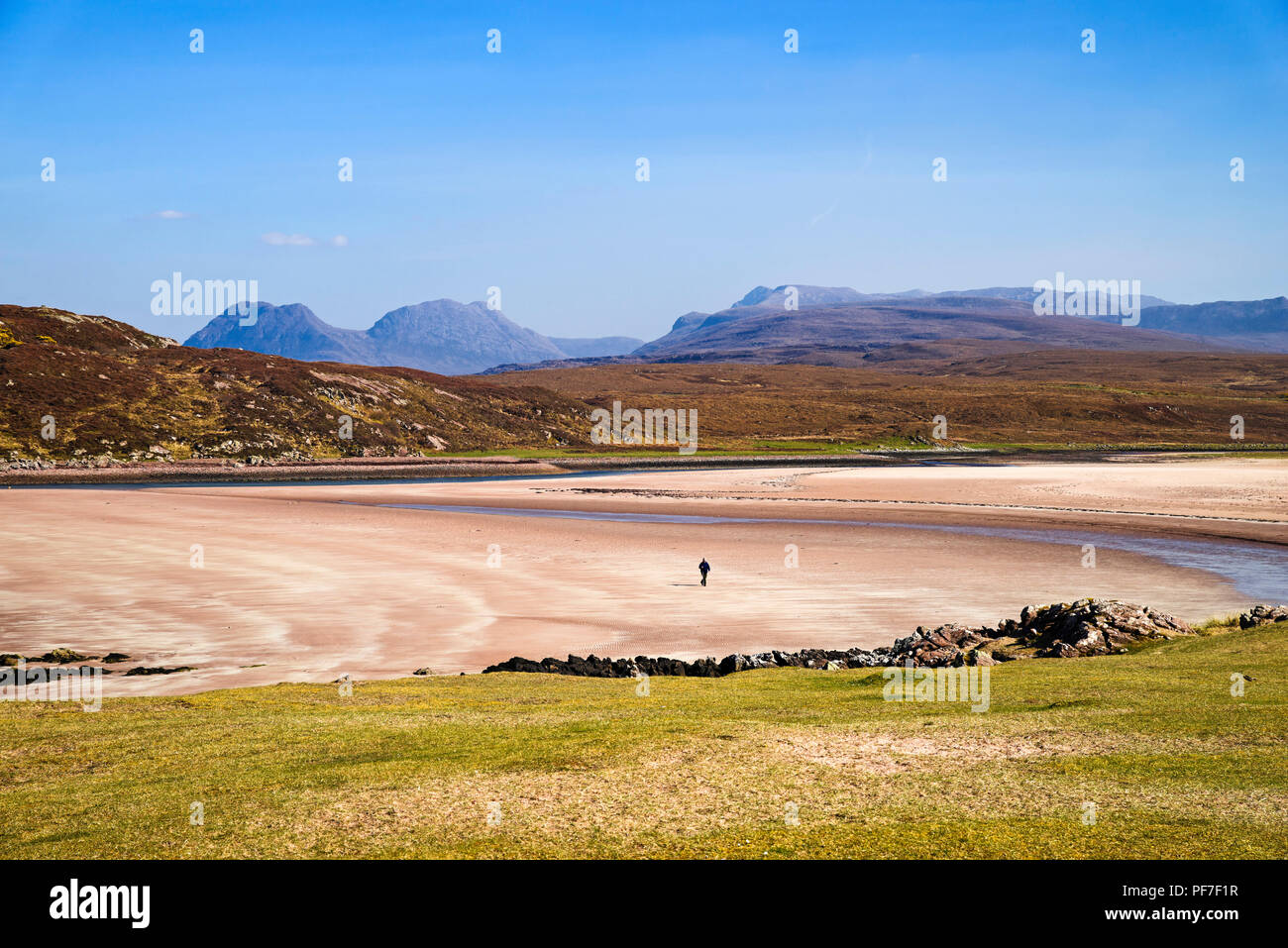 Einsamer Wanderer schreiten über Remote leeren Strand, achnahaird Bay, Coigach, Scottish Highlands, Beinn eine Eoin und Ben More Coigach steigende hinter sich. Stockfoto