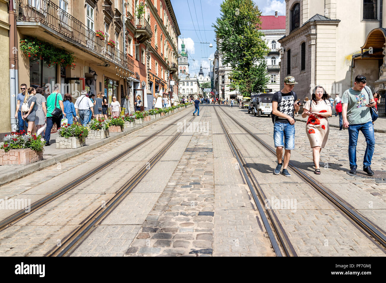 Lemberg, Ukraine - August 1, 2018: Trolley Straßenbahnschienen im historischen Ukrainischen polnische Stadt in der Altstadt mit Menschenmenge, Schiene, Kaffee Cafe Geschäfte, resta Stockfoto