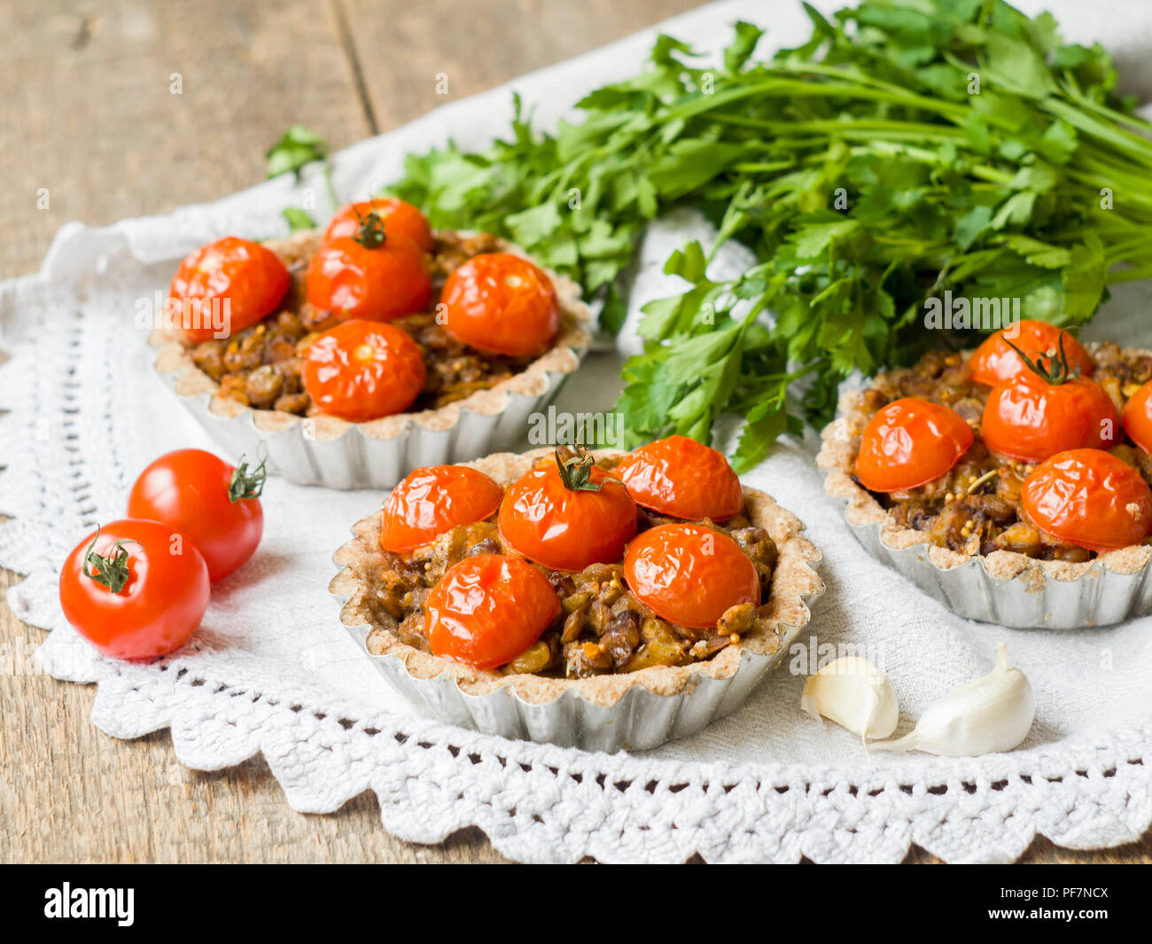 Vegane Ernährung Torten mit Linsen und Kirschtomaten auf rustikalen Hintergrund. Stockfoto