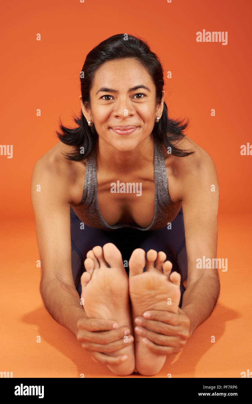Sitz nach vorne beugen Yoga Asana pose Frau auf der studio Hintergrund Stockfoto