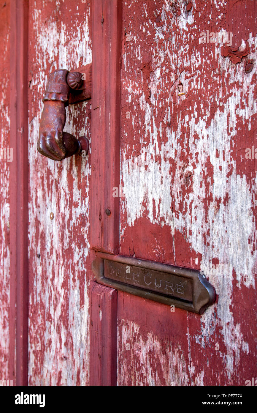 Klopfer und eine Mailbox im Namen 'Mr Le curé' auf einer hölzernen Tür mit abblätternder Farbe, Frankreich Stockfoto