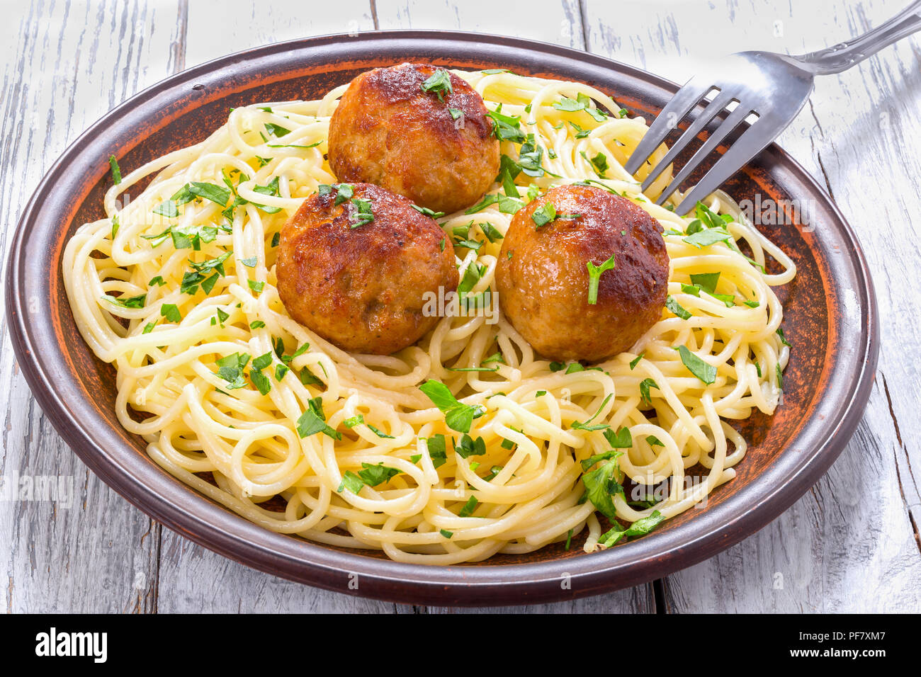 Spaghetti Nudeln mit Hackfleischbällchen mit gehackter Petersilie bestreut, Ansicht von oben Stockfoto