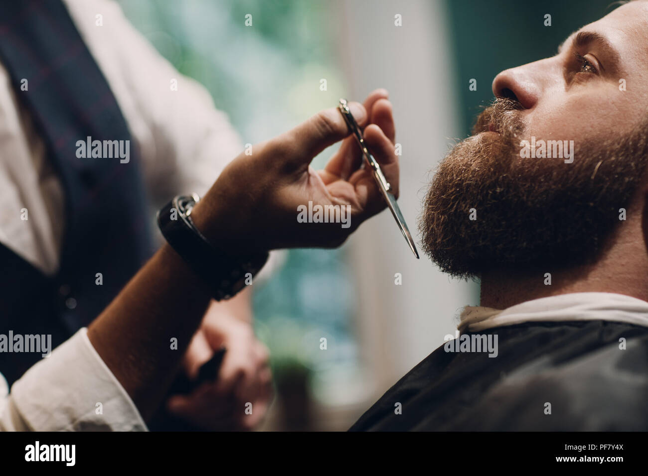 Barbershop Konzept. Bart Modell Mann und Friseur mit einer Schere. Stockfoto