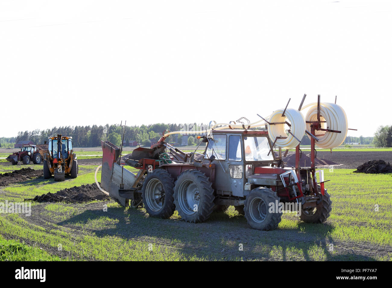 Traktoren und Bagger auf dem Feld, eine Drainage Stockfotografie - Alamy