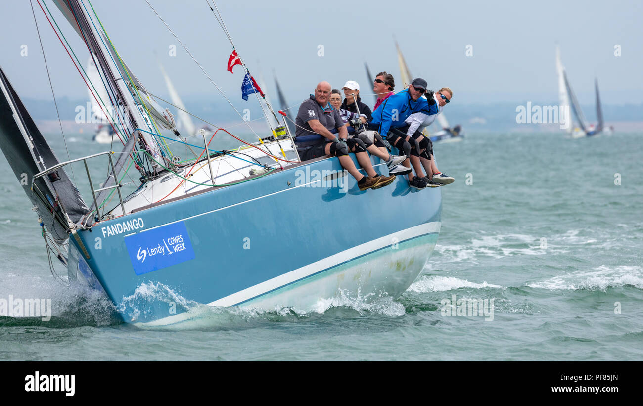 Den Solent, Hampshire, UK; 7. August 2018, Blick Richtung Bogen der Betuchten Yacht Racing in Cowes Week Regatta mit Crew sitzt auf der Seite des Bootes Stockfoto