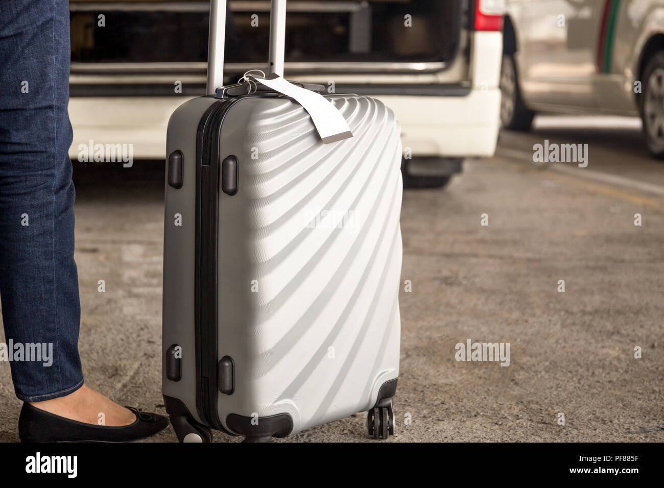 Frau touristische stehend mit Gepäck warten auf ein Taxi am Flughafen Stockfoto