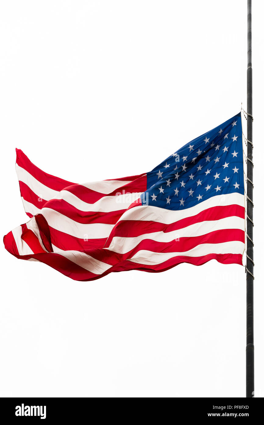Usa Flagge zum halben Angestellten Winken gegen den grauen Himmel Stockfoto