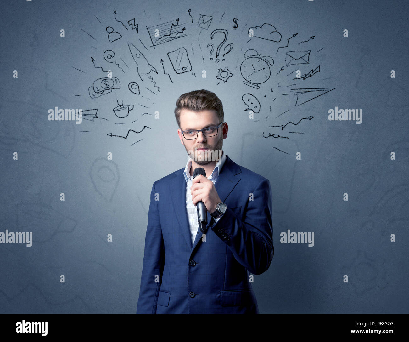 Geschäftsmann sprechen in das Mikrofon mit gemischten Doodles über seinem Kopf Stockfoto