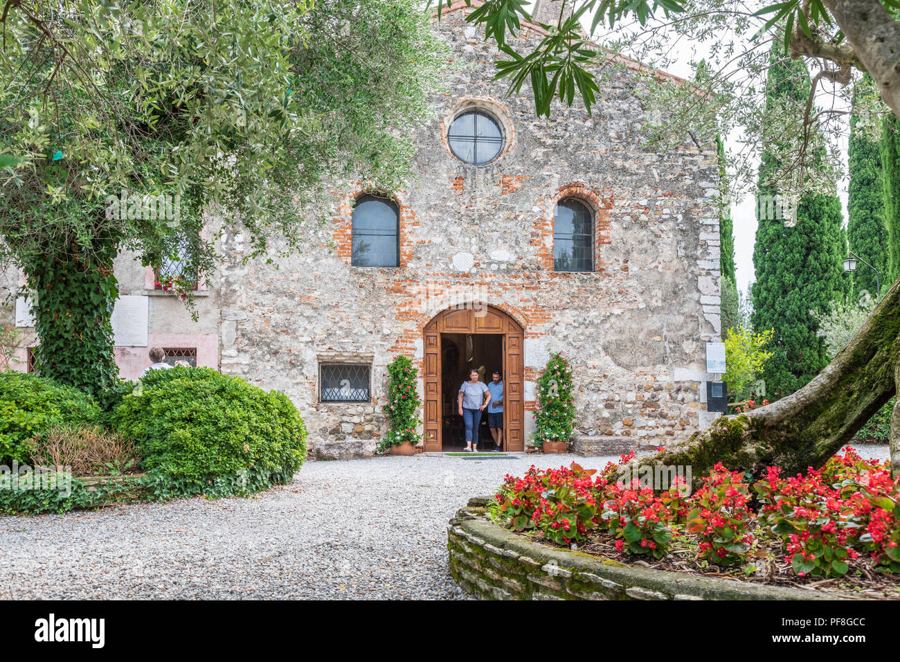 Die Chiesa di San Pietro Kirche in Sirmione. Die Fassade und die Piazza in von der Chiesa di San Pietro ist von Oliven- und Kastanienbäumen umgeben Stockfoto