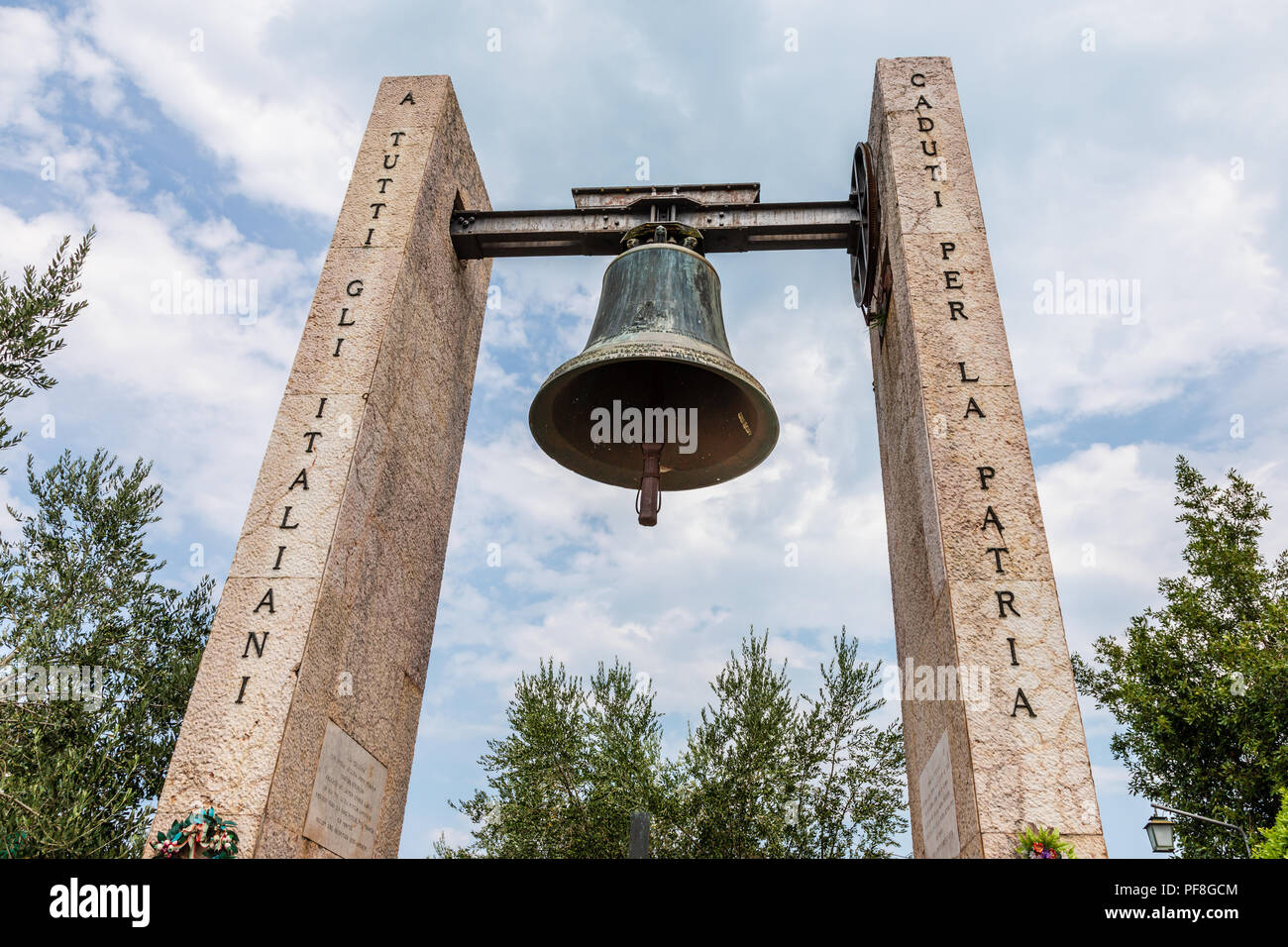 Das kriegerdenkmal Glocke auf der Piazza vor der Kirche Chiesa di San Pietro in Sirmione eine touristische Stadt am Ufer des Gardasees in der Lombardei Stockfoto