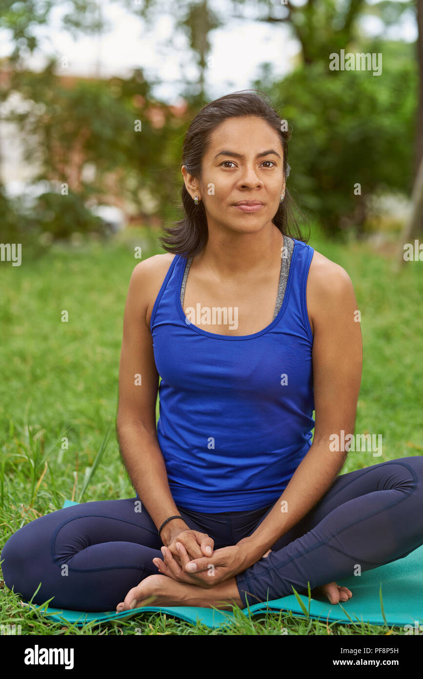 Junge Frau sitzen auf Yoga Matte in natürlichen Sommer Park Hintergrund Stockfoto