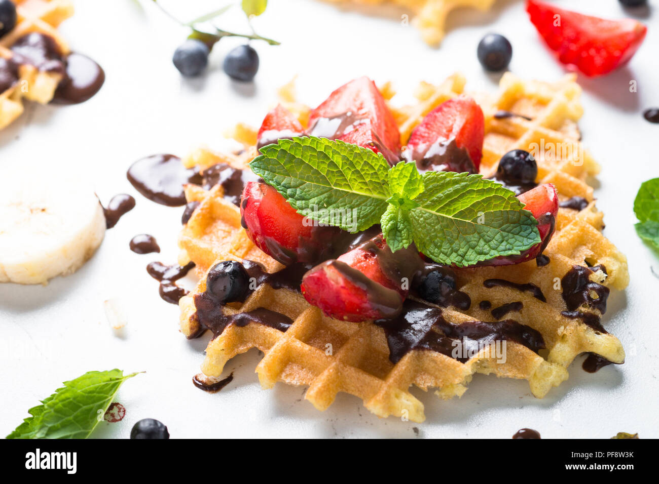 Waffeln mit frischen Erdbeeren und Schokolade Topping. Süße Nachspeise auf weißem Hintergrund. Close Up. Stockfoto