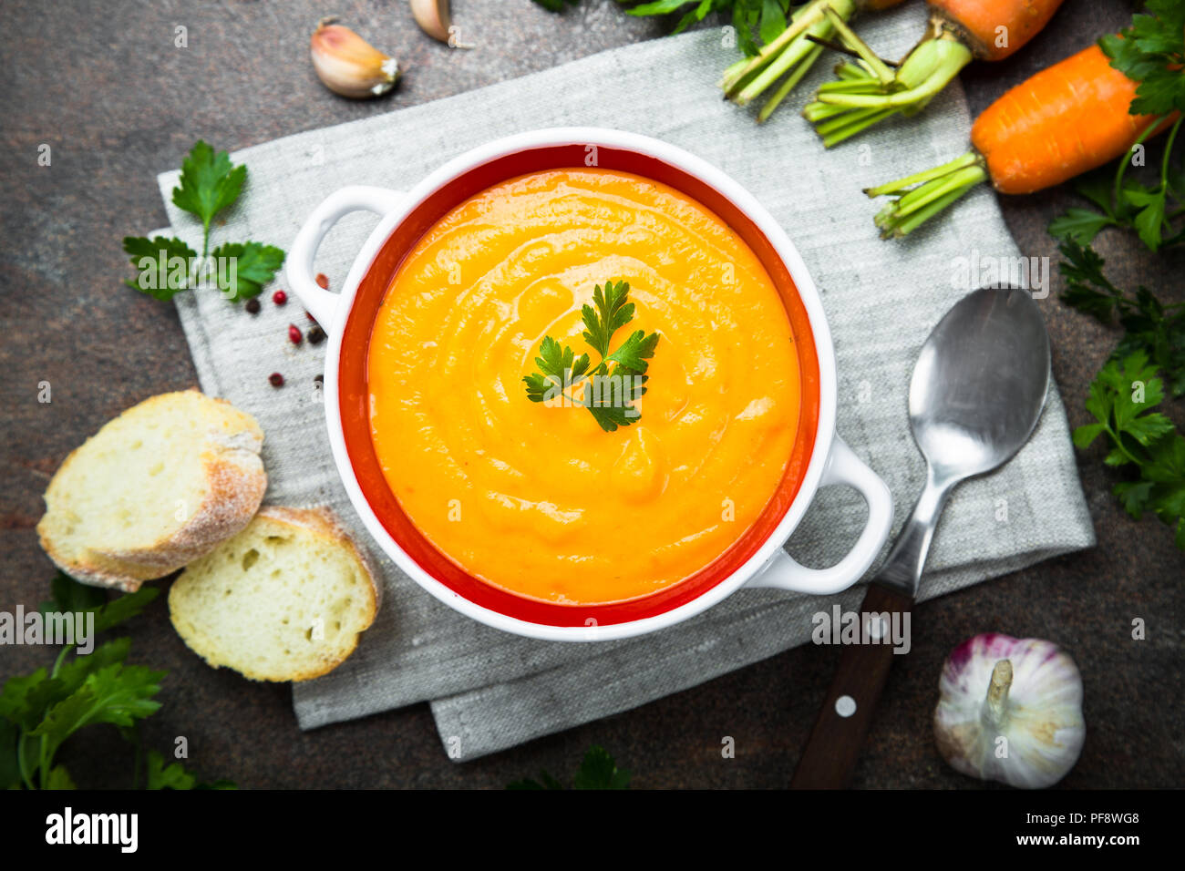 Karotten Kürbis creme Suppe auf dunklen Tisch aus Stein. Vegetarisches Gemüse Suppe. Ansicht von oben. Stockfoto