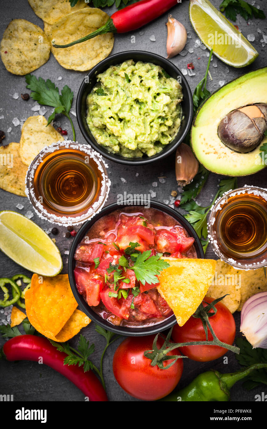 Lateinamerikanische mexikanisches Essen party Soße Guacamole, Salsa, Chips und Tequila auf Schwarz. Stockfoto