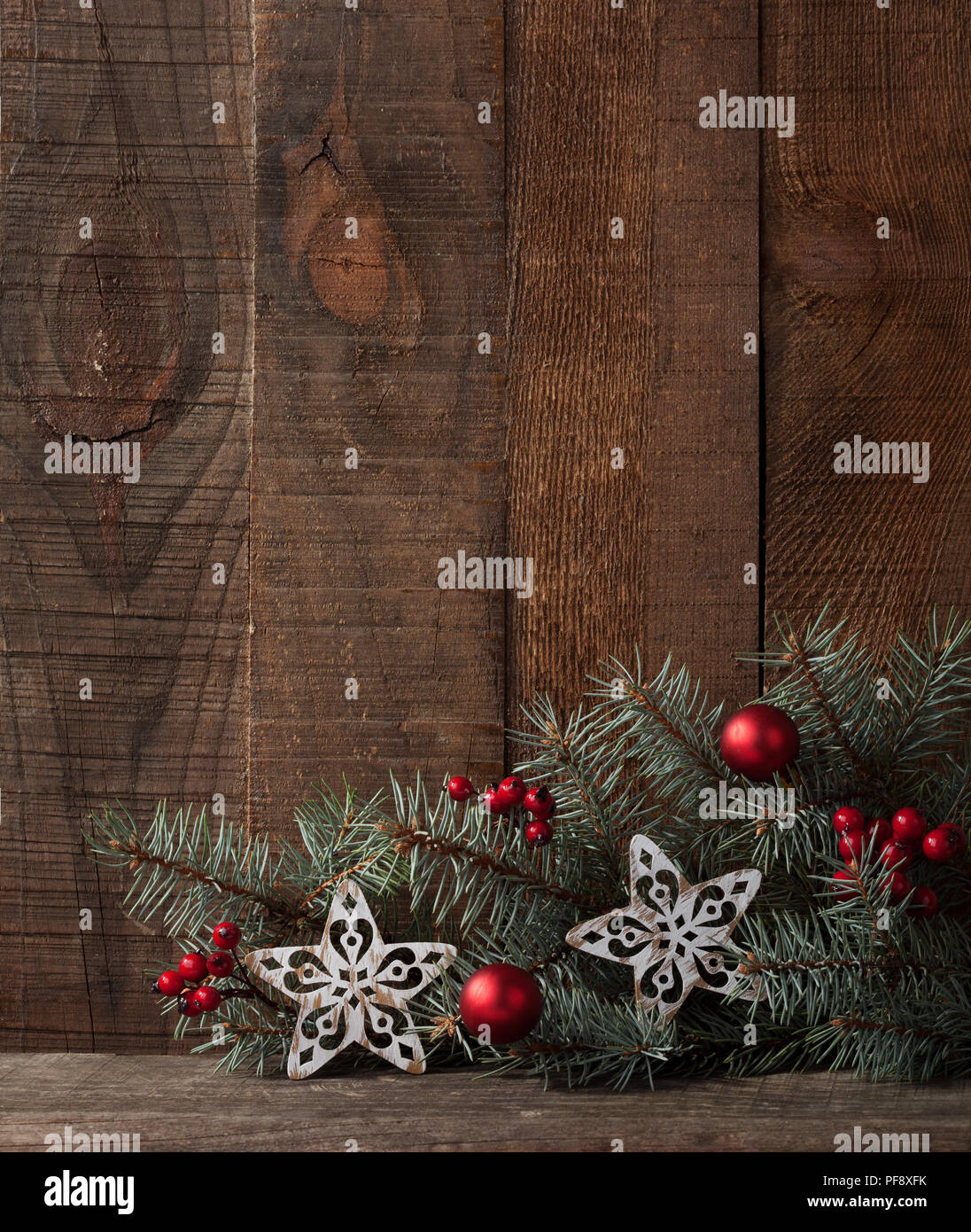 Tanne Zweig mit Weihnachtsschmuck auf rustikalen Holzmöbeln Hintergrund mit Kopie Platz für Text. Stockfoto