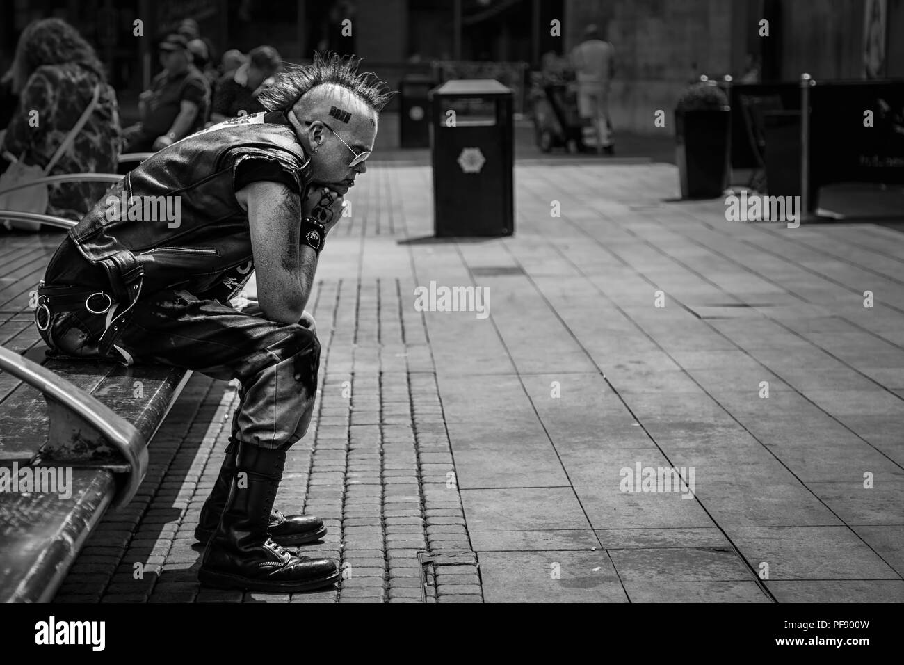 Punk Rocker saß in Piccadilly Gardens im Stadtzentrum von Manchester, England, Großbritannien Stockfoto