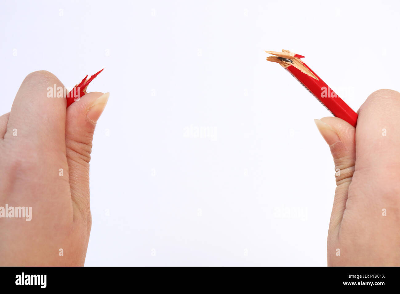 Zwei Hände halten einen roten Bleistift, die gerade unter dem Druck aufgeschnappt hat. Konzept der Stress, Ärger, Druck am Arbeitsplatz, parenting eine Stockfoto