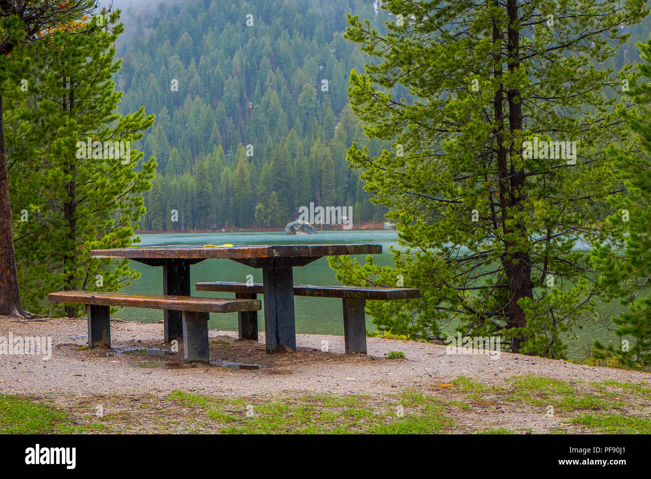 Schöne im Hinblick auf metallische und hölzernen Tisch einen Stuhl in der Seeufer mit einer wunderschönen Landschaft vom Jenny See im Grand Teton Nation Stockfoto