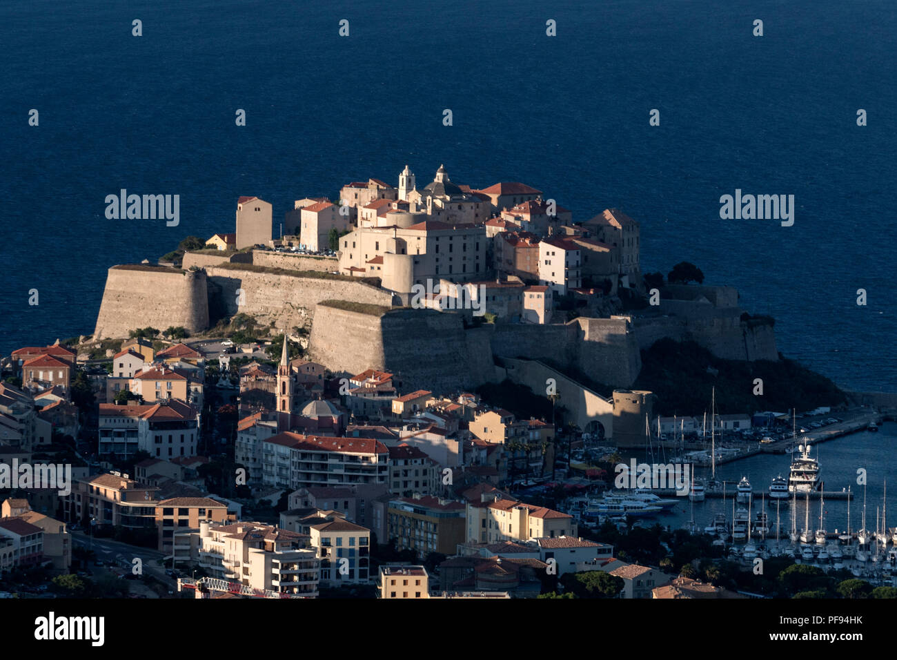 Am späten Abend Sonnenlicht getaucht, ist die Zitadelle von Calvi thront auf einem Felsen mit Blick auf die Altstadt von Calvi Calvi Bucht an der Nordwestküste von Korsika Stockfoto