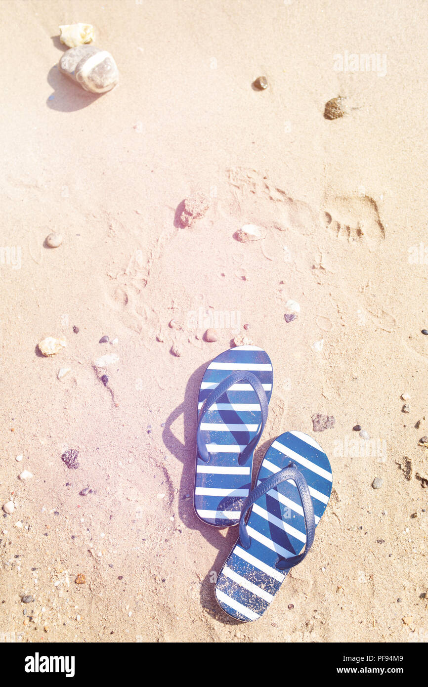 Stiped flip flops auf dem Sand. Im Sommer entspannen. Stockfoto