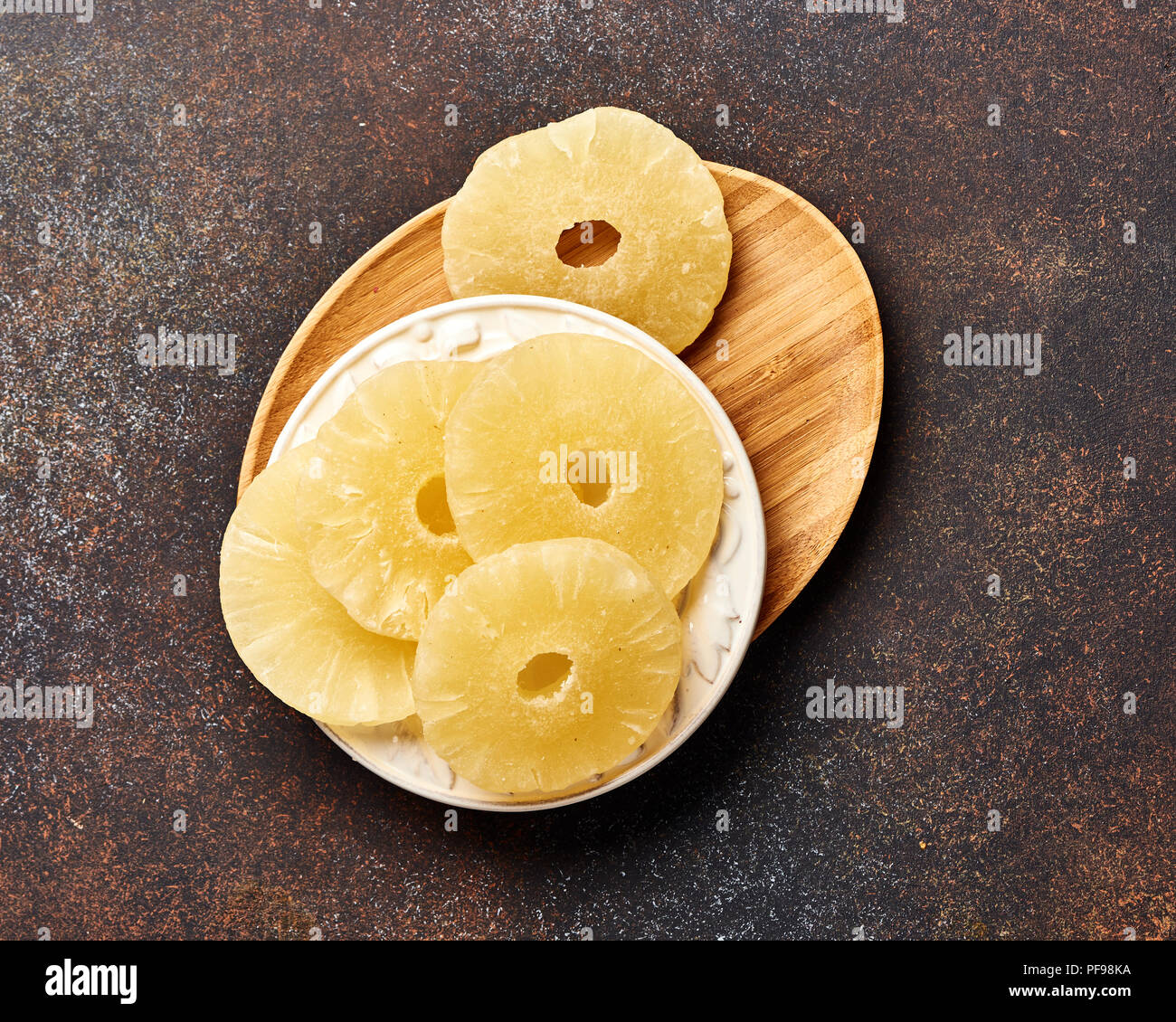 Getrocknete Ananas Ringe auf einem braunen Tisch. Top viw Süße paneapple Schichten. Stockfoto