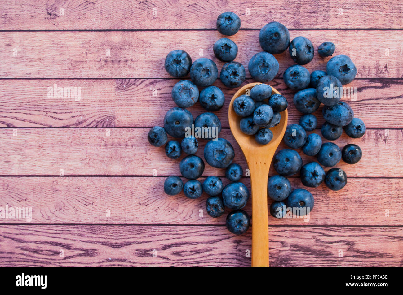 Frisch und saftig Blaubeeren in einem Löffel aus Holz auf Holz Tisch mit Copyspace. Gesunde Ernährung Konzept. Stockfoto