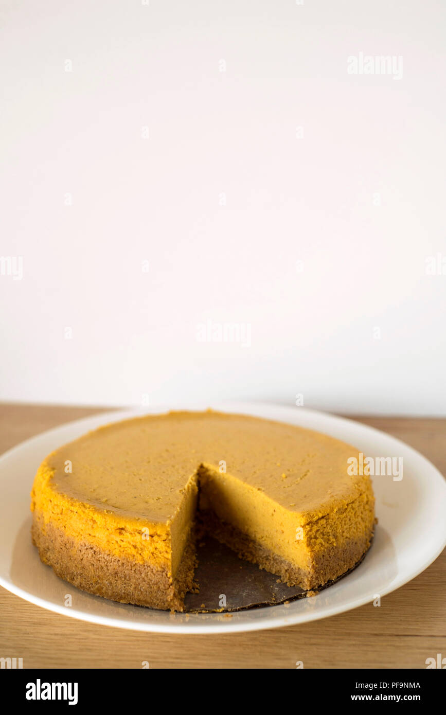 Ein Herbst Kürbis Käsekuchen mit einer Scheibe fehlt Stockfoto