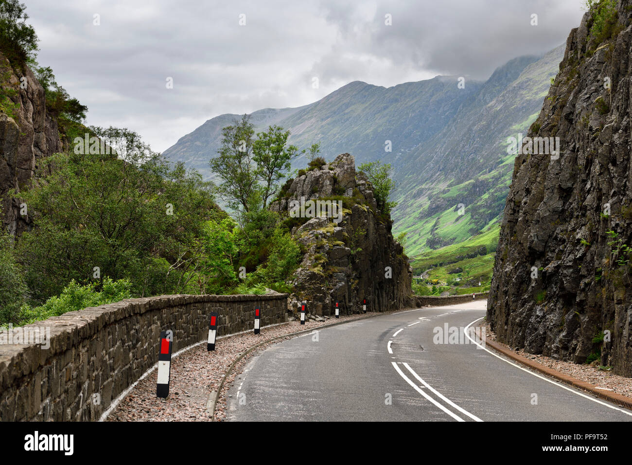 Geschwungene Autobahn A 82 durch Felsen mit Aonach Eagach Ridge Mountains nördlich von Glen Coe tal Schottischen Highlands Schottland Großbritannien Stockfoto