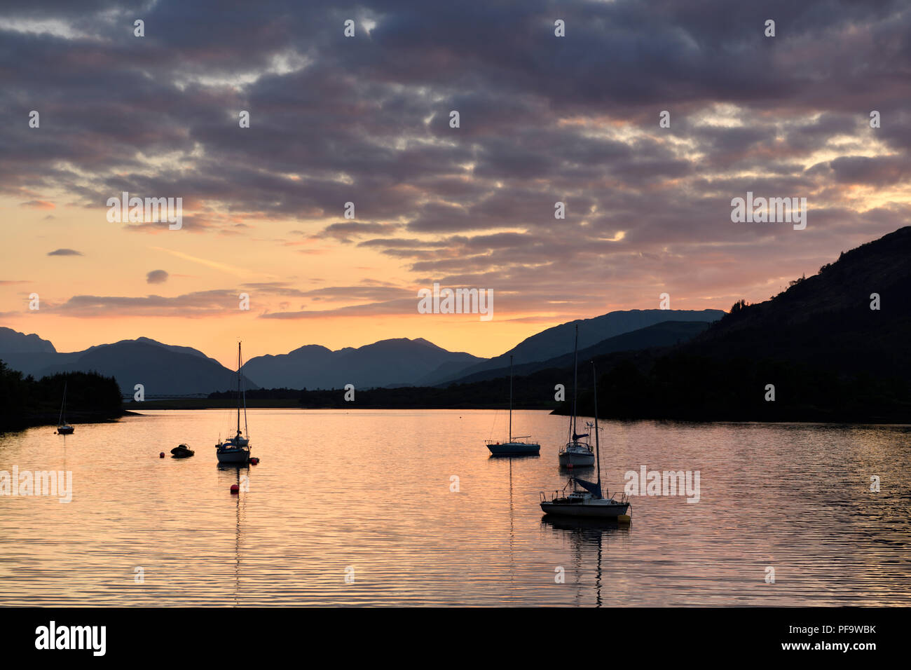 Günstig chartern Segelboote auf Loch Leven mit roter Himmel Sonnenuntergang Wolken bei Glencoe Yacht Club und fernen Sgurr Dhomhnuill peaks Schottischen Highlands Schottland Stockfoto