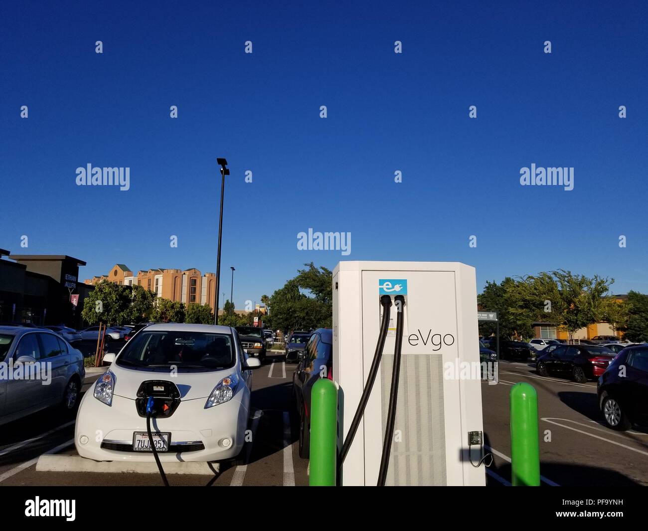 Elektroauto gesteckt Aufladen an eine eVgo Elektrofahrzeug Ladestation in einem Parkplatz in Dublin, Kalifornien, 20. Juni 2018 und. () Stockfoto