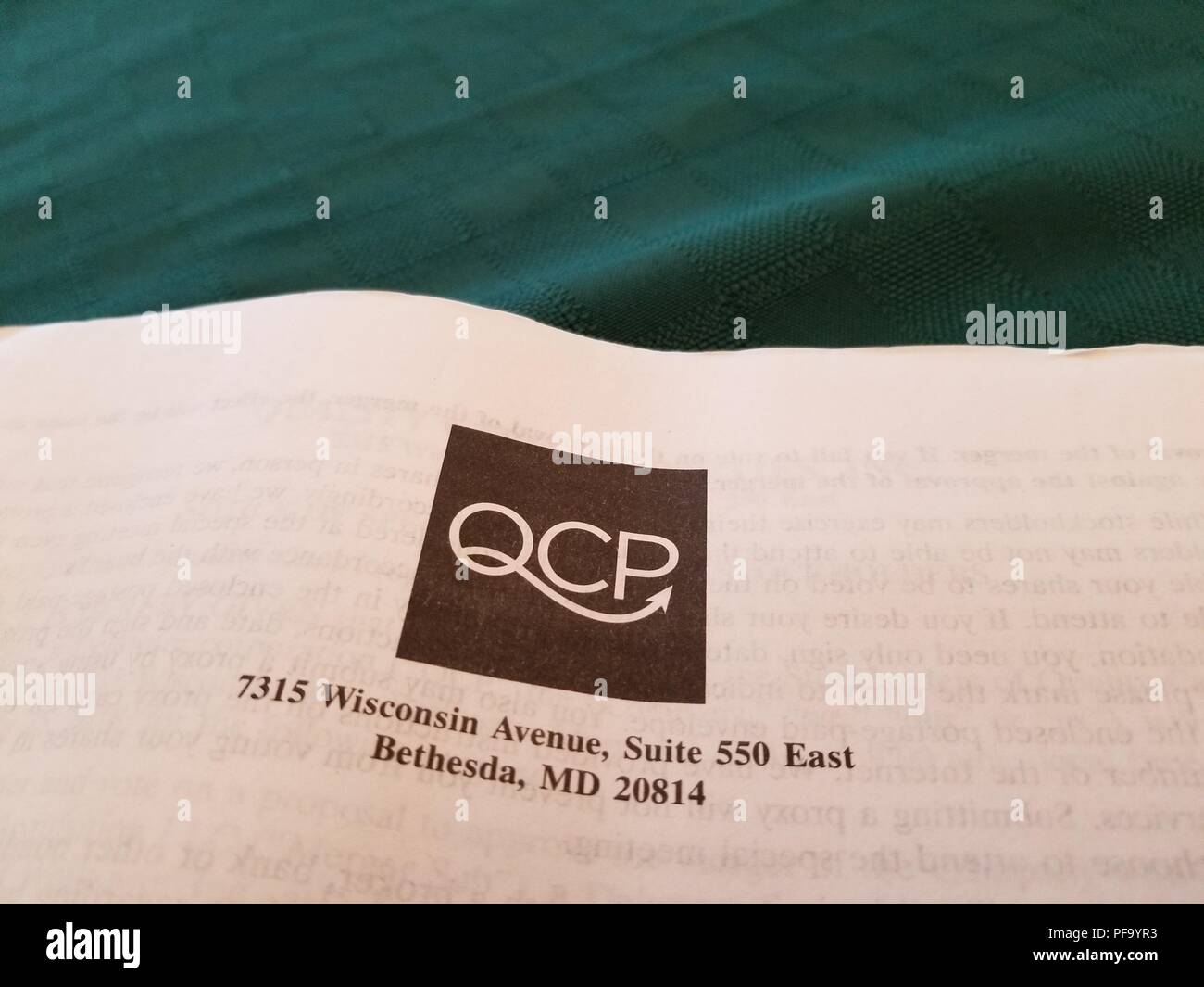 Close-up Logo für das Gesundheitswesen Immobilien Unternehmen Qualität Pflege Eigenschaften (QCP) auf Papier auf grünem Gewebe, San Ramon, Kalifornien, 2. Juli 2018. () Stockfoto