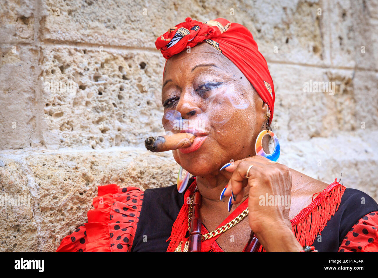 Kubanische Frau rauchen Zigarre in farbenfrohen traditionellen Outfit, Portrait von lokalen Frauen in Havanna, Kuba posing Stockfoto