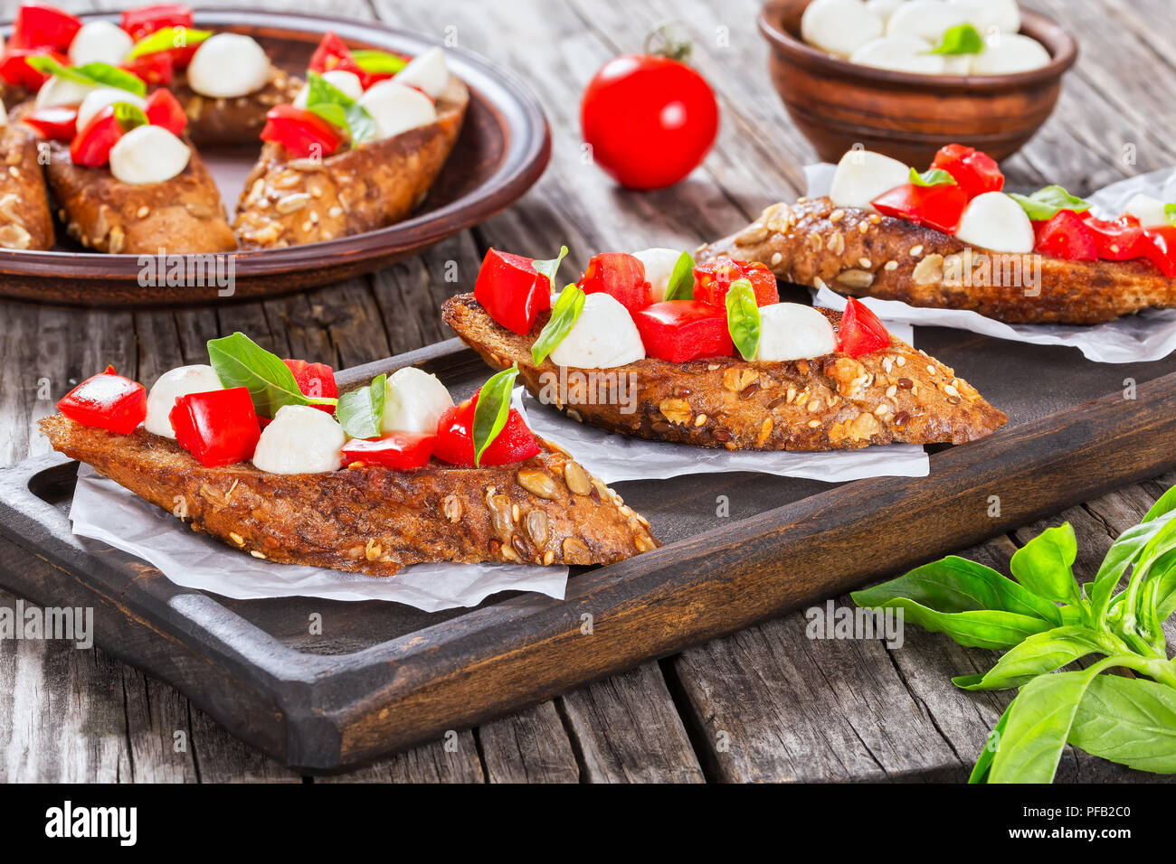 Bruschetta mit Tomaten, Mozzarella und Basilikum auf Roggen Baguette ...