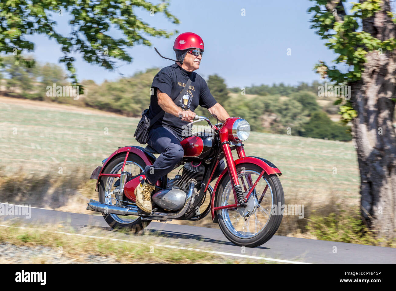 Ein Mann auf einem Motorrad, Jawa 250, Tschechische Republik alter Mann in einem Retro von 50 auf einer Landstraße aktiver Senior Mann Stockfoto