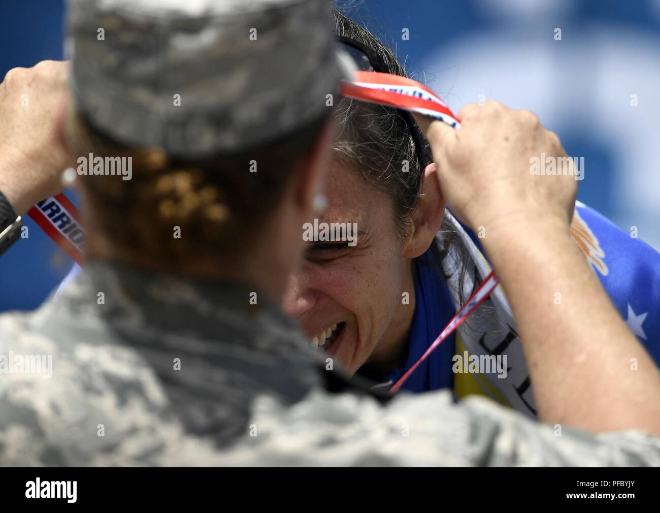 Team Luftwaffe Mitglied Oberstleutnant Audra Lyons erhält eine Medaille von Brig. Gen. Kathleen Koch, Geschäftsführer der Air Force Services, während ein Verteidigungsministerium Krieger spiele Siegerehrung bei der US Air Force Academy in Colorado Springs, Colorado, 6. Juni 2018. Konkurrieren in der Spiele sind service Mitglieder und Veteranen mit Oberkörper, niedriger - Körper und Rückenmarksverletzungen; Schädel-Hirn-Verletzungen; Sehbehinderung; schwere Krankheiten; und post-traumatischen Stress. Jeder der 39 teilnehmenden Athleten der Luftwaffe wird in einem oder mehreren der 11 Sportarten wie Bogenschießen, Radfahren, Schießen konkurrieren, Bedienungsanleitung Stockfoto